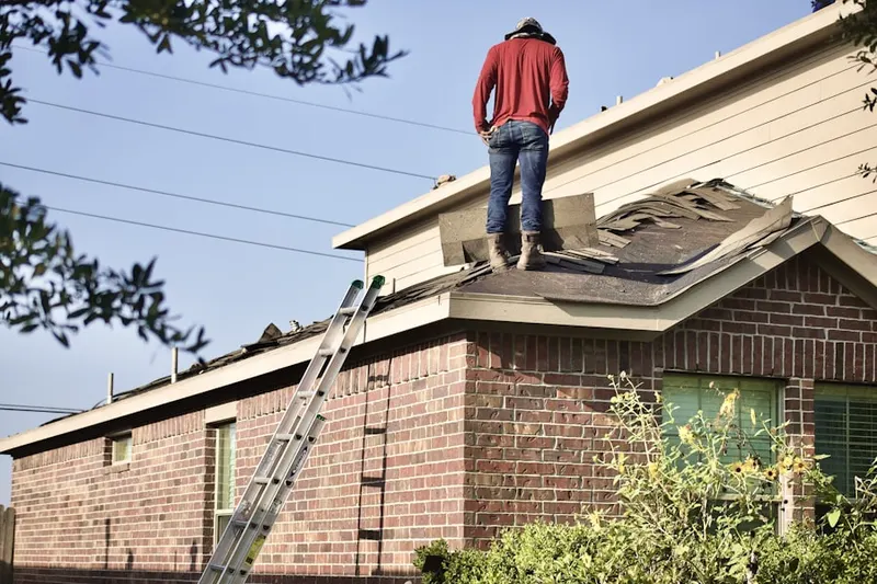 Professional roofer working on a residential roof in Port-au-Peck